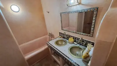 a bathroom with a sink and a mirror and a tub at Dar S'BAH in Fès