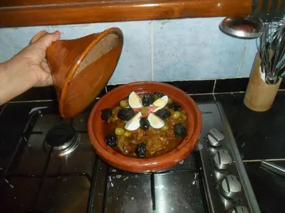 a person holding a pot of food in a bowl at Maison d'Hôtes Ghalil in Ouarzazate