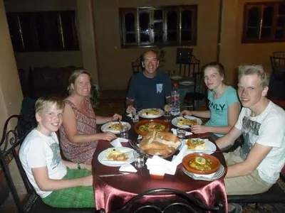 a group of people sitting around a table eating food at Maison d'Hôtes Ghalil in Ouarzazate