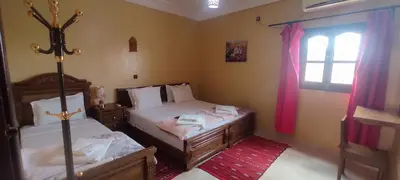 a bedroom with two beds and a window at Maison d'Hôtes Ghalil in Ouarzazate
