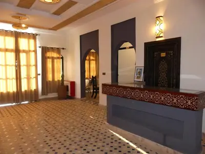 a room with a fireplace and a counter in a room at Riad La Luna in Merzouga