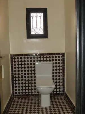 a bathroom with a toilet and a window at Riad La Luna in Merzouga
