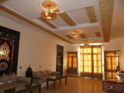 a living room with a couch and a table at Riad La Luna in Merzouga