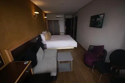 a hotel room with a bed and a couch at Hôtel Belle Vue et Spa in Meknès