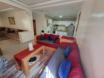 a living room with a red couch and a table at Tranquil Oasis in the Heart of Ifrane in Ifrane