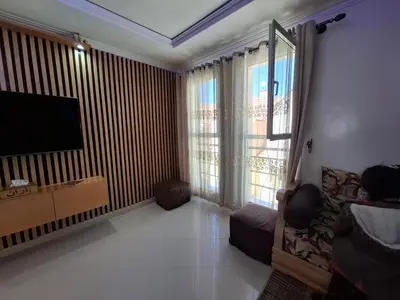 a living room with a flat screen tv and a large window at Tranquil Oasis in the Heart of Ifrane in Ifrane