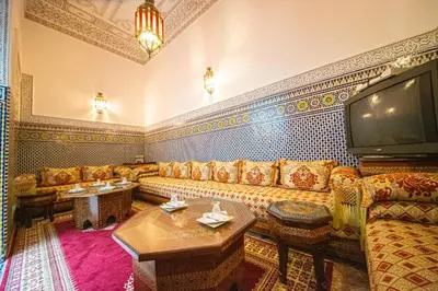 a living room with a couch and a tv at Riad Baba in Fès