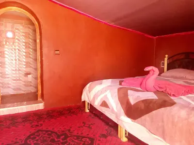 a bedroom with a bed with a pink flamingo on it at Sahara Camp Light in Mhamid