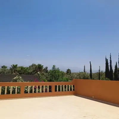 a balcony with a wooden fence with trees in the background at Villa Ama in Marrakech