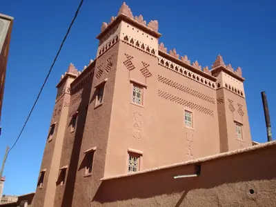 a large brick building with writing on the side of it at Kasbah Ait Kassi in Boumalne