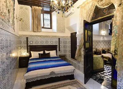 a bedroom with a bed and a chandelier at Dar Aya Fes in Fès