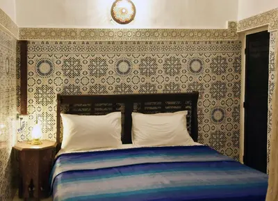 a bedroom with a bed with a patterned wall at Dar Aya Fes in Fès