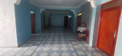 a hallway with a room with blue walls and a chair at Hotel Complex Europe in Guercif