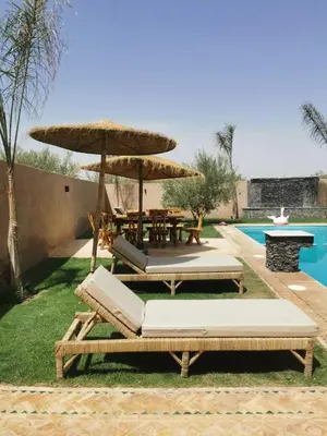 a patio with a table and chairs and an umbrella at Villa Baraka in Marrakech