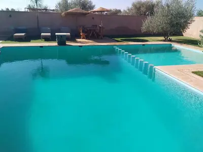 a swimming pool with blue water in a yard at Villa Baraka in Marrakech