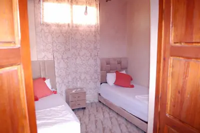 two beds in a small room with red pillows at Villa Baraka in Marrakech