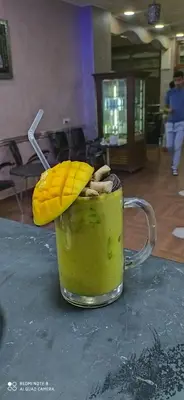 a cup of green liquid with a banana on top at Hotel Achark in Bou Arfa