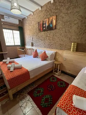 a bedroom with a bed and two rugs at Tazart Lodge in Marrakech