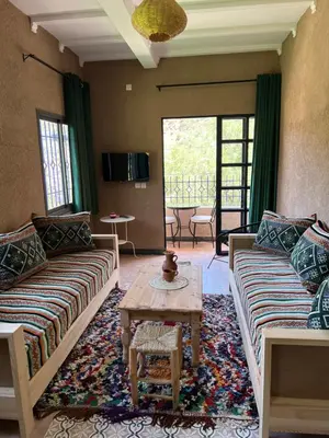 a living room with two couches and a table at Tazart Lodge in Marrakech