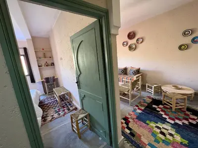 a room with a green door and a living room at Tazart Lodge in Marrakech