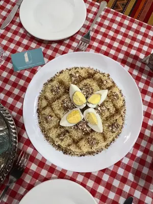a pizza on a white plate on a red and white table at Tazart Lodge in Marrakech