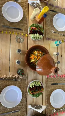 a wooden table with plates and bowls of food at Tazart Lodge in Marrakech