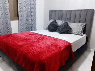 a bed with a red blanket and two pillows at Private, Air Conditionner and Free Parking in Fès