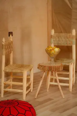 a room with two chairs and a bowl of fruit on a table at Desert Magic Camp in Merzouga