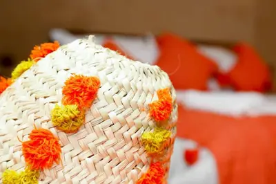 a white hat with flowers on it on a bed at Desert Magic Camp in Merzouga