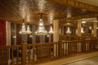 a lobby with chandeliers and a staircase in a building at Hotel Tafilalet in Meknès