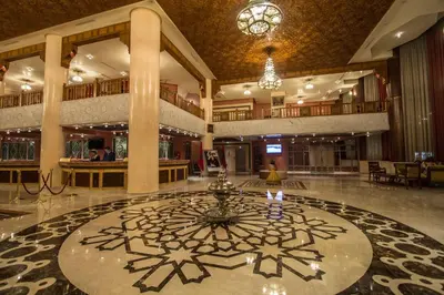 a lobby with a large clock in the middle of it at Hotel Tafilalet in Meknès