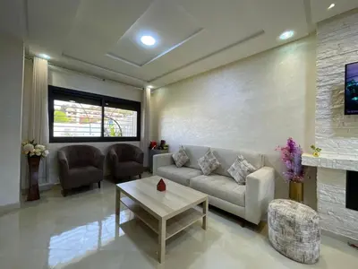 a living room with a couch and a table at Chalet villa QUE POUR LES FAMILLES in Imouzzer Kandar