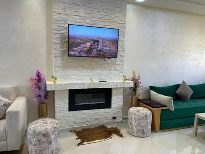 a living room with a fireplace with a flat screen tv at Chalet villa QUE POUR LES FAMILLES in Imouzzer Kandar