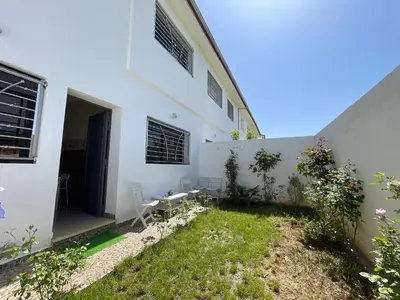 a courtyard of a white building with a yard at Chalet villa QUE POUR LES FAMILLES in Imouzzer Kandar