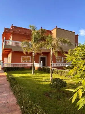 a house with palm trees in front of it at AYOR FES in El Oulaij