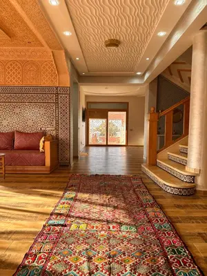 a living room with a red couch and a rug at AYOR FES in El Oulaij