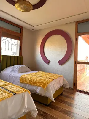 a bedroom with two beds and a mirror on the wall at AYOR FES in El Oulaij