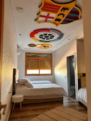 a bedroom with a bed with a painting on the ceiling at AYOR FES in El Oulaij