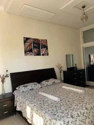 a bedroom with a large bed with a comforter at Appartement meublé à louer in Meknès