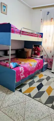 a bedroom with two bunk beds and a checkered floor at Appartement meublé à louer in Meknès