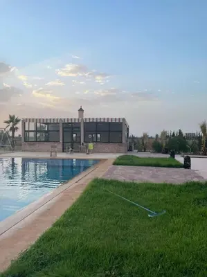 a large building with a swimming pool in front of it at Igrane House in Marrakech