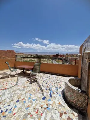 a patio with a table and chairs on a mosaic floor at Panoramic House - Midelt Family Triplexe in Midelt