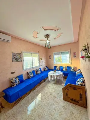 a large living room with blue couches and a table at Soofhouse in Fès