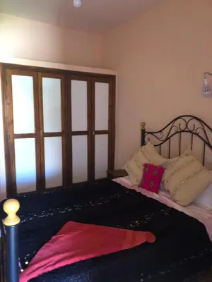 a bedroom with a bed with pillows on it at ACHAHOUD CHEz LA BELLE FIBULLE in Aït Fars