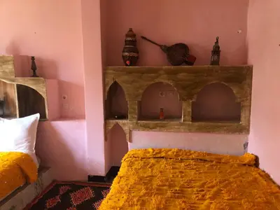 a bedroom with a bed and shelves on the wall at ACHAHOUD CHEz LA BELLE FIBULLE in Aït Fars