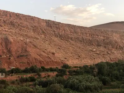 a dirt hill with trees and a mountain at ACHAHOUD CHEz LA BELLE FIBULLE in Aït Fars