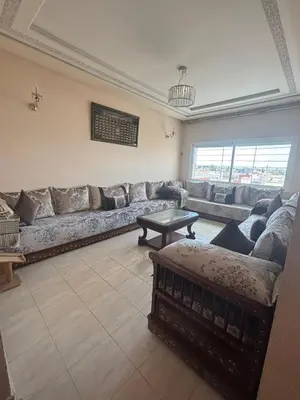a living room with a large couch and a table at Cozy Corner Getaway, Fez 4th floor in Fès