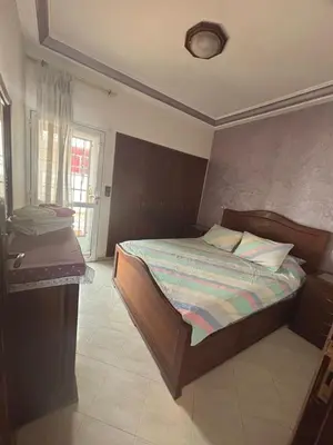 a bedroom with a bed and a table in it at Cozy Corner Getaway, Fez 4th floor in Fès