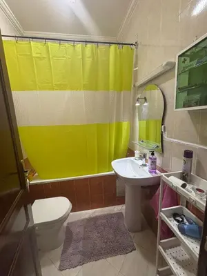 a bathroom with a yellow shower curtain and a sink at Cozy Corner Getaway, Fez 4th floor in Fès