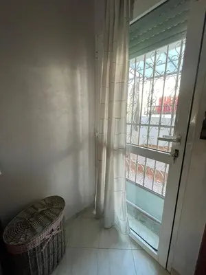 a room with a window and a wicker stool next to a door at Cozy Corner Getaway, Fez 4th floor in Fès